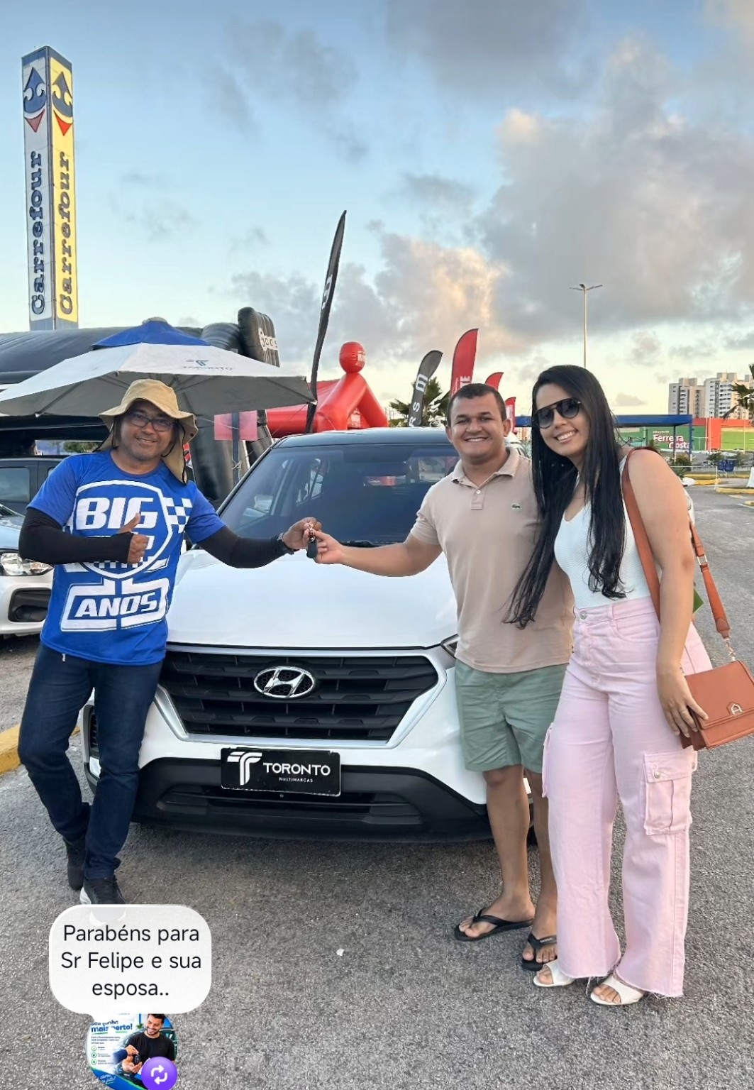 Casal recebendo as chaves de um veículo