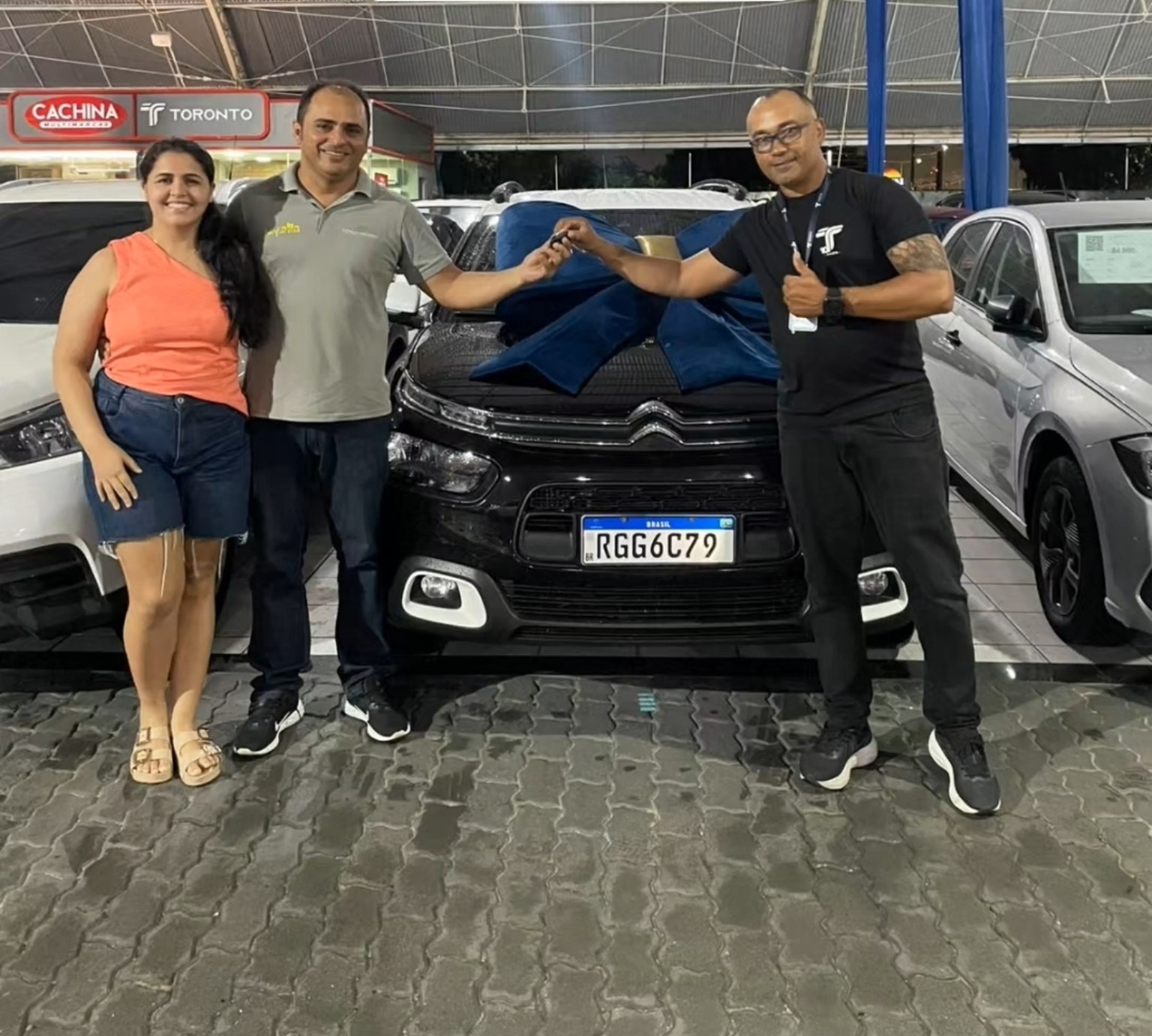 Casal recebendo as chaves de um carro